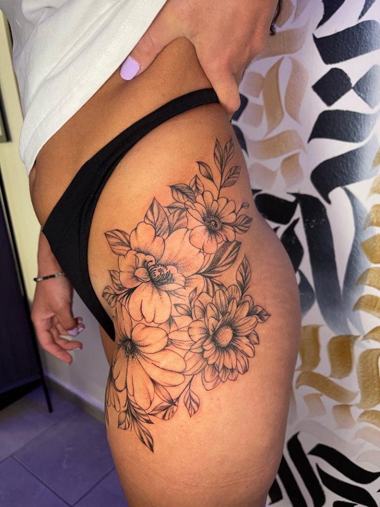 composición floral en el muslo de una chica